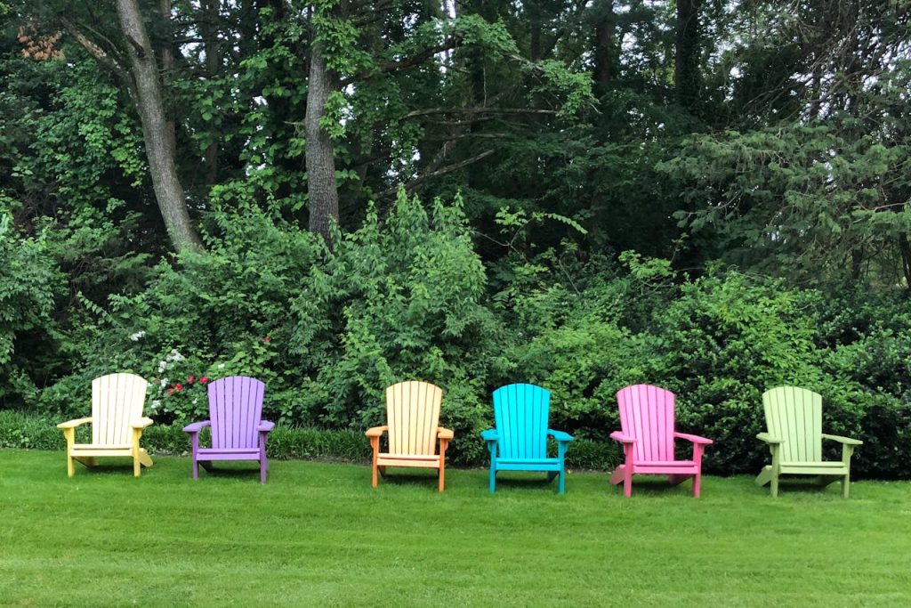 Colorful Adirondack chairs set against lush greenery in Middletown, PA, USA.
